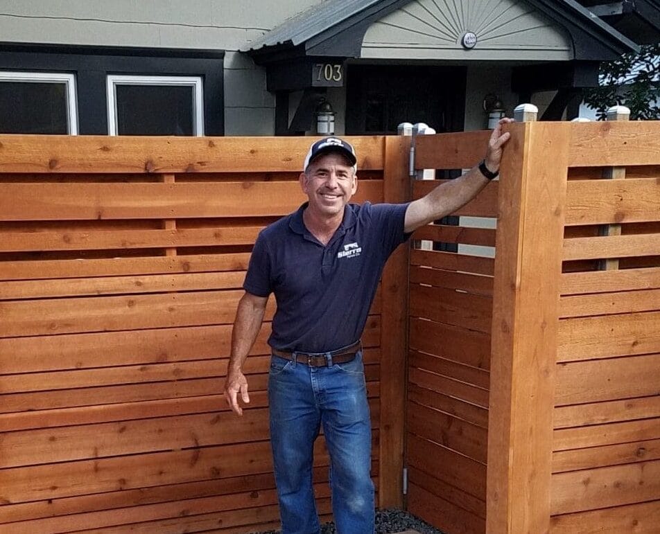 Sierra Fence's Richard Novigrod standing beside a modern horizontal cedar fence installation in Austin Texas