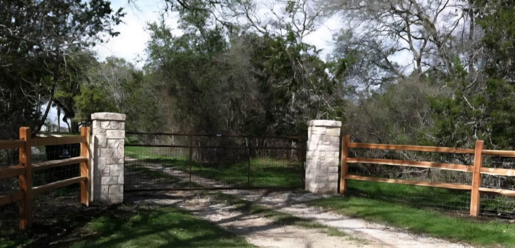 Split-rail fence entryway with limestone columns.