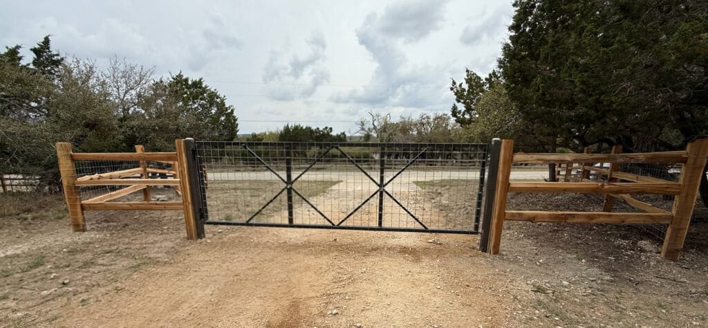 Split-rail fence with added wire mesh and a custom gate.