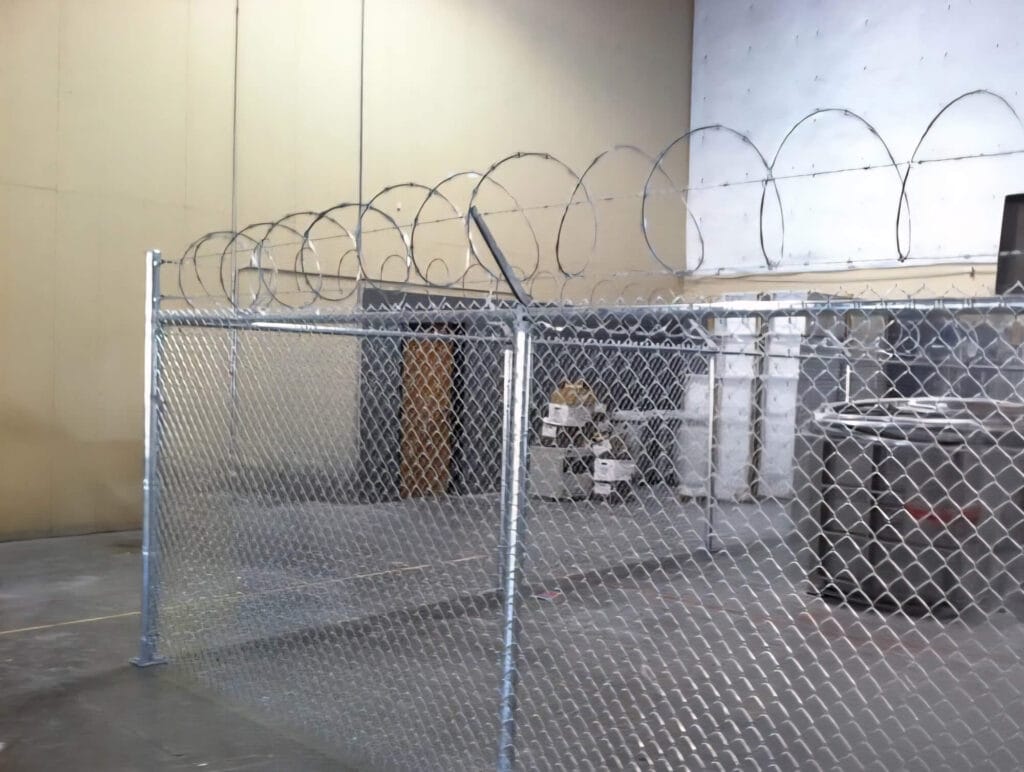 Indoor security fence with barbed wire.