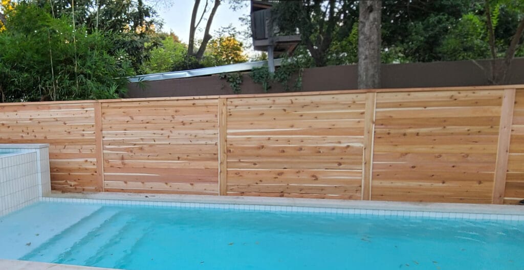Horizontal pool fence with a decorative top cap installed by Sierra Fence in Central Texas.
