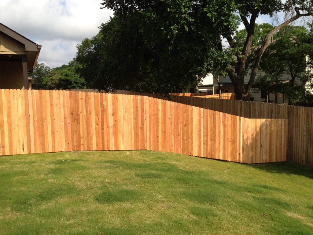 Narrow picket cedar fence following natural slope for a clean, professional finish