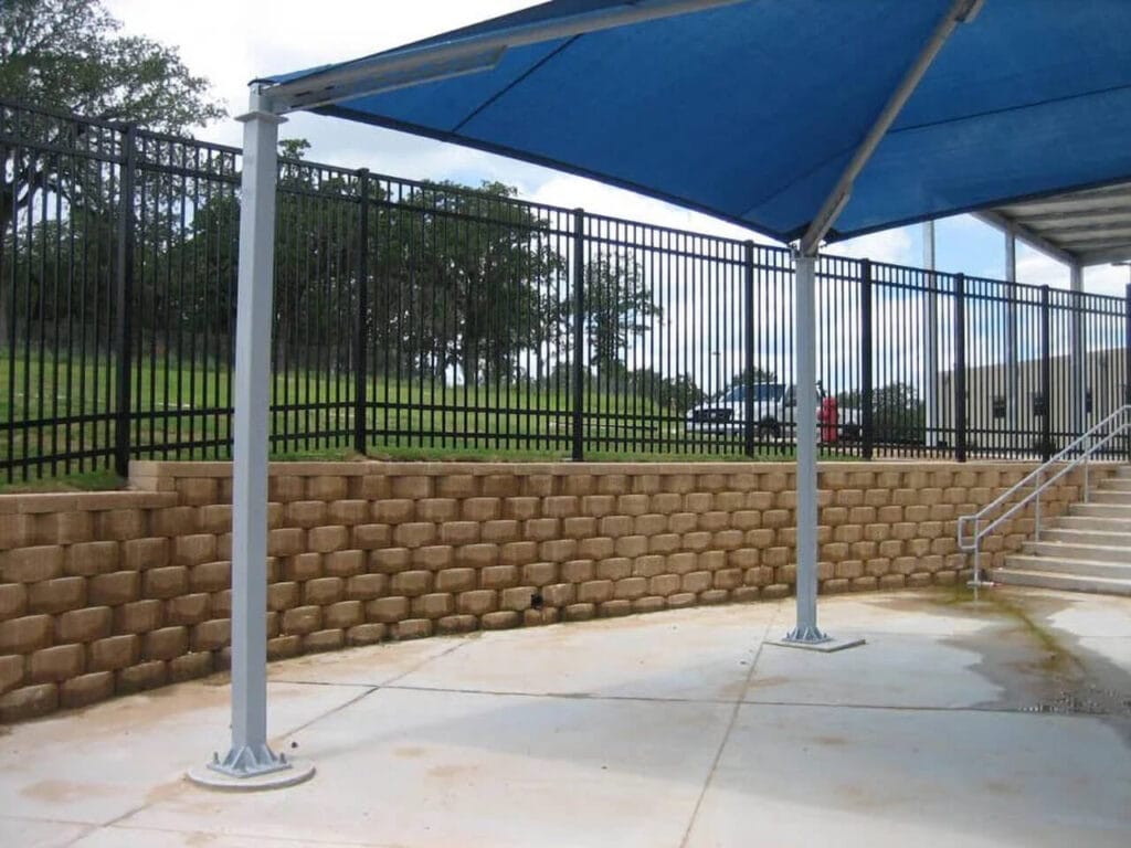 Ameristar four-rail ornamental steel fence mounted on stone wall combining beauty and strength.