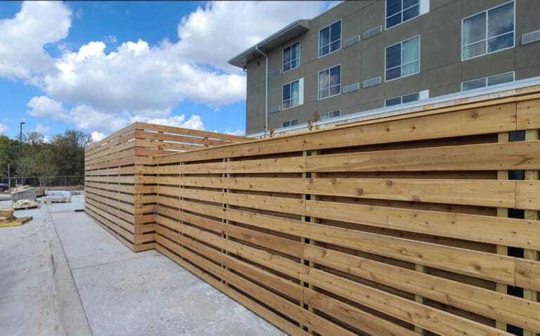Modern horizontal board-on-board cedar fence providing privacy and style for commercial perimeter.