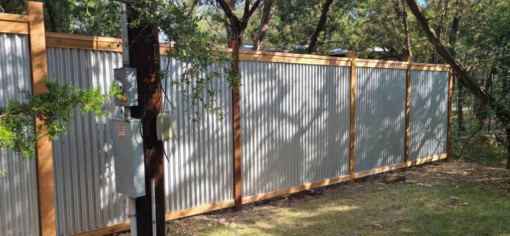 Corrugated metal privacy fence with cedar frame delivering contemporary industrial look.