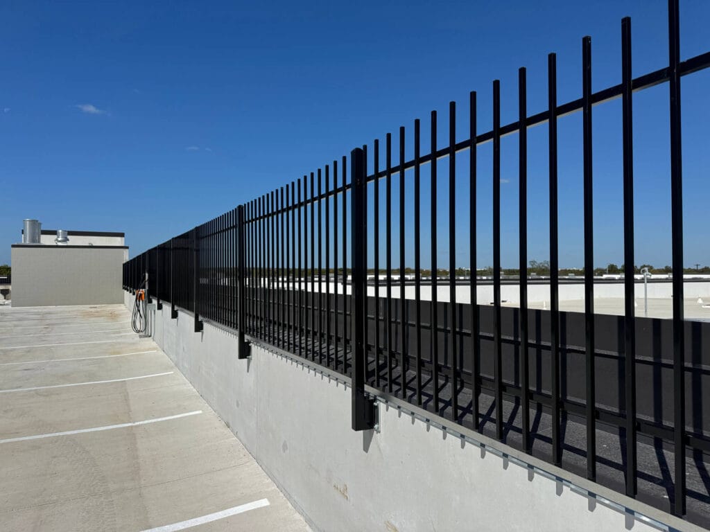 Iron safety railing along parking garage edge providing protection without blocking view.
