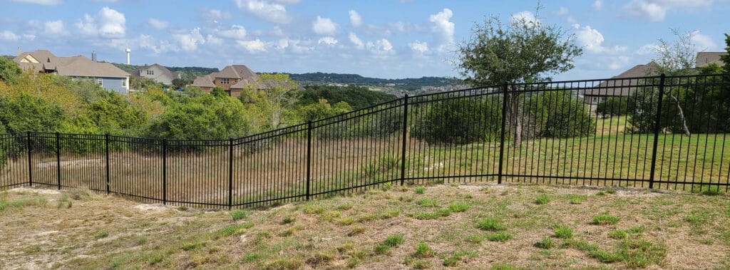 Ornamental steel fence following natural grade in the Hill Country