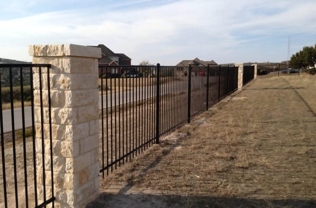 Masonry columns paired with ornamental iron fencing for elegant commercial perimeter design.