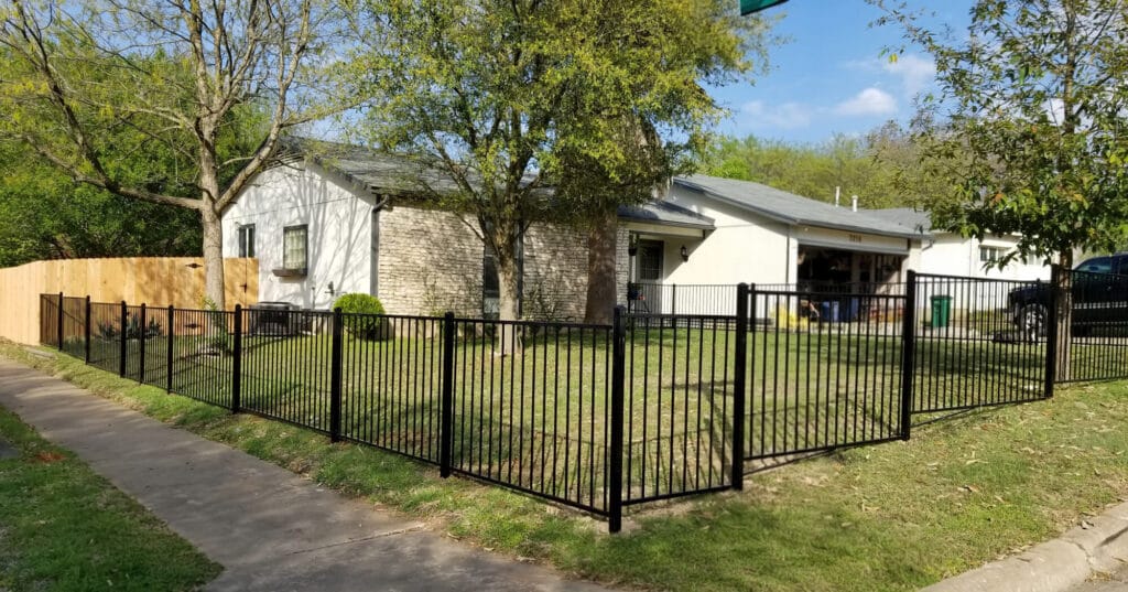 Low-profile ornamental iron fence defining a front yard